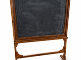 un vieux tableau noir posé sur un support en bois, sur fond blanc