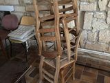 several wooden chairs are stacked on top of each other in a room