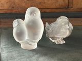 deux oiseaux en verre posés sur une table à côté d'une commode