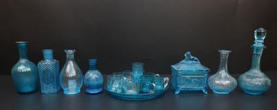 de nombreux vases en verre bleu posés sur une table