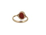 a close up of a gold ring with a red stone