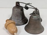 two bells and a wooden toy on a white surface