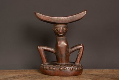 une vieille sculpture en bois représentant un chat assis sur une table en bois