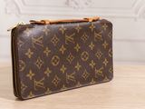 a louis vuitton wallet on a wooden table