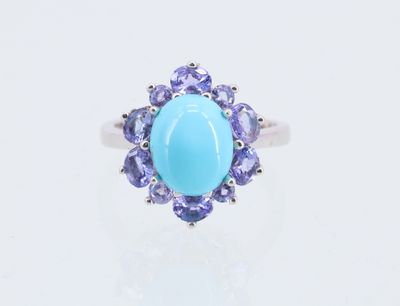 une pierre ovale de couleur turquoise, entourée de pierres de tanzane et de tanzane