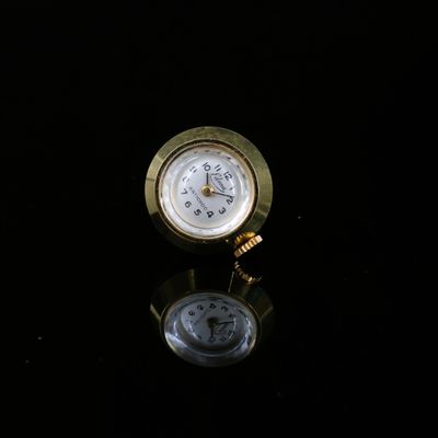 une horloge dorée posée sur une surface noire