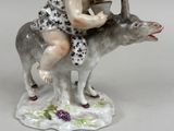 a figurine of a boy riding on a donkey