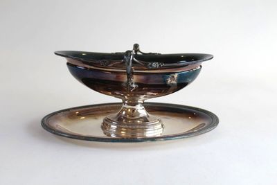 a silver plate with a bowl on top of it