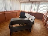 un bureau avec une chaise et une étagère dans le coin