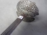a silver object with a wooden handle on a table