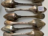 six silver spoons are lined up on a table with a price tag