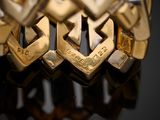 a close up of a gold bracelet on a black surface
