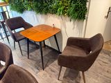 plusieurs chaises et une table dans une pièce dont l'un des murs est recouvert de plantes