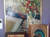 tableau accroché au mur d'une pièce violette, représentant un vase de fleurs et des tableaux