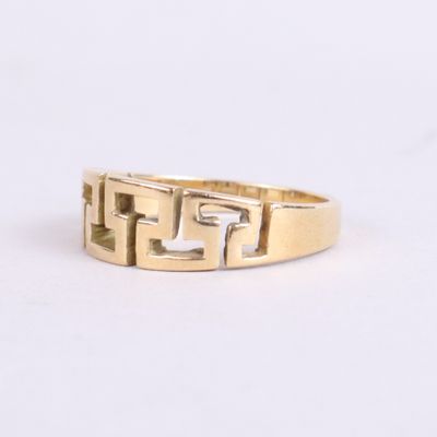 a close up of a gold ring on a white surface