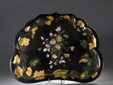 assiette noire et dorée, décorée de fleurs et de feuilles peintes