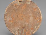an image of a brown plate on a stand on a gray surface