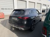 the rear of a black mercedes suv parked in front of a building