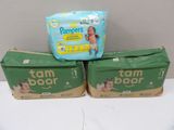 three boxes of baby diapers sitting on top of a table