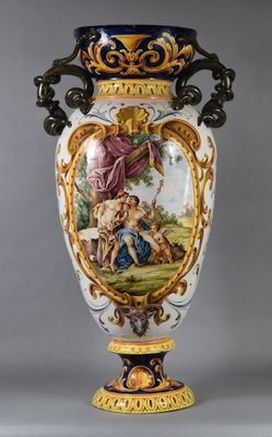 un grand vase avec un tableau posé sur une table