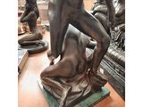 a bronze statue of a man and a woman on a table