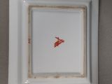 square white plate with a red arrow on it on a gray surface