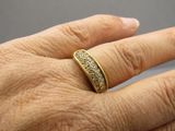 la main d'une femme à laquelle est passée une bague en or