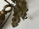 a brass clock with a chain hanging from it ' s side