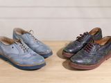 two pairs of shoes sitting on top of a wooden table