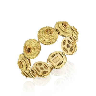 gros plan d'un bracelet en or sur fond blanc