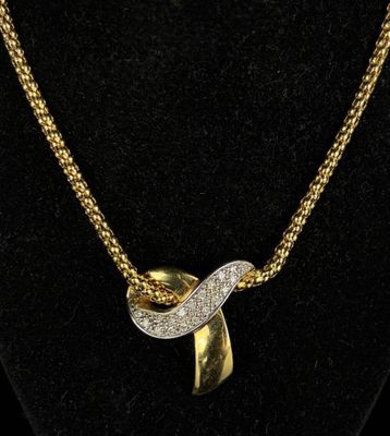 a gold and diamond necklace on a mannequin neck