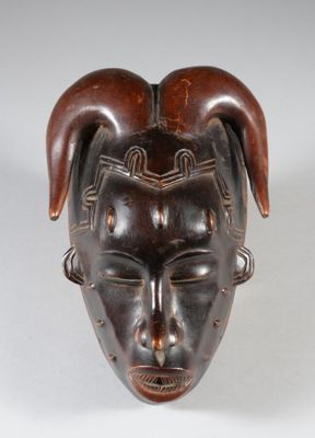 une image représentant un masque en bois orné de cornes sur la tête
