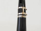 a close up of a black and gold fountain pen with a white background