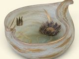 a glass bowl with a flower in it on a table