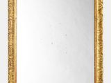 une image d'un miroir encadré d'or sur un mur blanc
