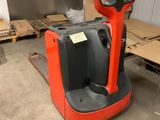 un chariot élévateur rouge dans un entrepôt avec des palettes