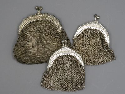 trois sacs à main anciens en maille argentée sur fond gris