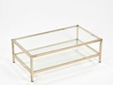 une table basse en verre et laiton avec un plateau en verre transparent