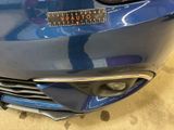 a close up of a blue car with a sticker on the front of it