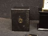 a small clock sitting next to a book on the ground