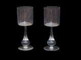 pair of clear glass goblets on a black background