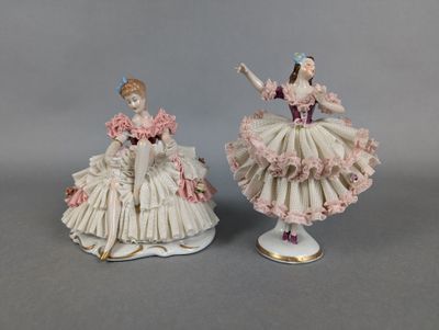 pair of porcelain figurines of a woman in a dress and a man in a tuxedo
