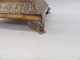 a silver plate with a bird on it on a table