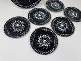six black and white plates with white designs on them on a table