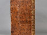 an old book sitting on top of a table next to a gray wall