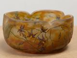 un bol marron orné de fleurs, posé sur une table