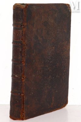 an old book sitting on top of a table next to a white wall