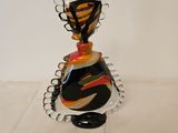 a glass vase with a black and orange design on it