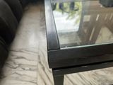 a glass table with a glass top sitting on a marble floor