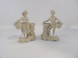 deux figurines représentant un homme et une femme portant des paniers sur la tête